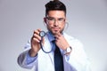 Young doctor listens concentrated at stethoscope Royalty Free Stock Photo