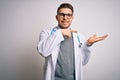 Young doctor man with blue eyes wearing medical coat and stethoscope over isolated background amazed and smiling to the camera Royalty Free Stock Photo