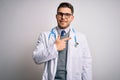 Young doctor man with blue eyes wearing medical coat and stethoscope over isolated background cheerful with a smile on face Royalty Free Stock Photo