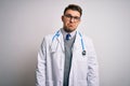 Young doctor man with blue eyes wearing medical coat and stethoscope over isolated background depressed and worry for distress, Royalty Free Stock Photo