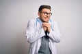 Young doctor man with blue eyes wearing medical coat and stethoscope over isolated background laughing nervous and excited with Royalty Free Stock Photo