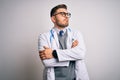 Young doctor man with blue eyes wearing medical coat and stethoscope over isolated background looking to the side with arms Royalty Free Stock Photo