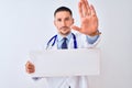 Young doctor man holding blank advertising banner over isolated background with open hand doing stop sign with serious and Royalty Free Stock Photo