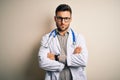 Young doctor man wearing glasses, medical white robe and stethoscope over isolated background skeptic and nervous, disapproving Royalty Free Stock Photo