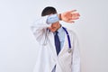 Young doctor man wearing stethoscope over isolated background covering eyes with arm, looking serious and sad Royalty Free Stock Photo