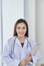 Young doctor or medic with clipboard and stethoscope standing on white background Royalty Free Stock Photo