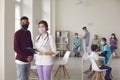 Nurse and patient in face masks standing in hospital office during vaccination campaign Royalty Free Stock Photo