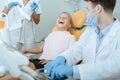 Young doctor and nurse in protective masks, gloves and uniforms looks at laughing girl Royalty Free Stock Photo