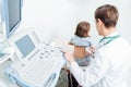 Young doctor performing kidney ultrasound scan on a ten year old girl