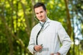 Young doctor portrait with stethoscope on the green Royalty Free Stock Photo