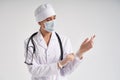 Young doctor putting on surgical gloves over white background Royalty Free Stock Photo