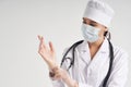 Young doctor putting on surgical gloves over white background Royalty Free Stock Photo