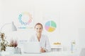 Doctor sitting at her desk in the office and smiling Royalty Free Stock Photo