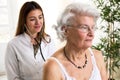 Young doctor with stethoscope exam senior woman Royalty Free Stock Photo