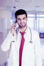 Young doctor talking on his mobile phone in hospital Royalty Free Stock Photo