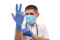 Young doctor in uniform getting ready to work putting on gloves isolated on a white background Royalty Free Stock Photo