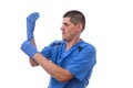 Young doctor in uniform getting ready to work putting on gloves isolated on a white background Royalty Free Stock Photo