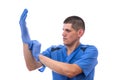 Young doctor in uniform getting ready to work putting on gloves isolated on a white background Royalty Free Stock Photo