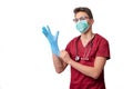 young doctor in uniform getting ready to work putting on gloves isolated on a white background Royalty Free Stock Photo