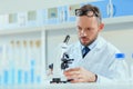 Young doctor in uniform working at testing laboratory at clinic