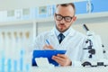 Young doctor in uniform working at testing laboratory at clinic