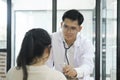 Young doctor is using a stethoscope listen to the heartbeat of the patient.