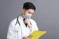 Young Doctor Wear Medical Mask looking at exam report