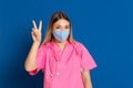 Young doctor wearing a mask face and a pink uniform Royalty Free Stock Photo