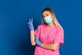 Young doctor wearing a mask face and a pink uniform Royalty Free Stock Photo