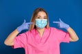 Young doctor wearing a mask face and a pink uniform Royalty Free Stock Photo