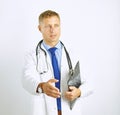 Young doctor in white coat with a stethoscope greets holding out his hand Royalty Free Stock Photo