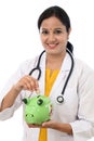 Young doctor woman holding a piggy bank Royalty Free Stock Photo