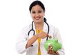 Young doctor woman holding a piggy bank Royalty Free Stock Photo