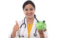 Young doctor woman holding a piggy bank Royalty Free Stock Photo