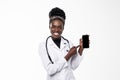 Young doctor african woman pointing on cellphone screen isolated on white background