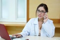 Young doctor woman speaking by phone mobile in her office Royalty Free Stock Photo