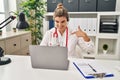 Young doctor woman wearing doctor uniform working using computer laptop pointing finger to one self smiling happy and proud Royalty Free Stock Photo