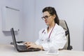 Young doctor woman working on laptop at the consult. Modern Medical concept indoors Royalty Free Stock Photo