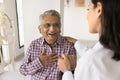 Young doctor woman calming senior Indian patient, holding mans hand Royalty Free Stock Photo