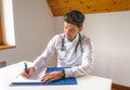 Young doctor writing report on paper Royalty Free Stock Photo