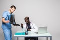 Young doctors discussing diagnosis in bright office. Two doctors disscusing xray at office table isolated on white background Royalty Free Stock Photo