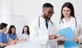 Young doctors using digital tablet, discussing diagnosis Royalty Free Stock Photo