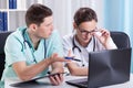 Young Doctors using laptop and talking Royalty Free Stock Photo