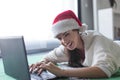 Young domestic woman online shopping for Christmas by laptop