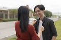 A young doting asian woman fixes her boyfriend\'s jacket. A loving girlfriend showing care and affection to her partner Royalty Free Stock Photo