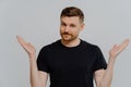 Isolated shot of confused young guy spreading hands sideways and feeling doubt while making choice Royalty Free Stock Photo