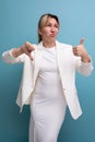 young doubtful well-groomed blond boss woman in a white jacket and dress