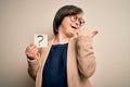 Young down syndrome business woman holding question mark paper as doubt symbol pointing and showing with thumb up to the side with Royalty Free Stock Photo