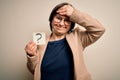 Young down syndrome business woman holding question mark paper as doubt symbol stressed with hand on head, shocked with shame and Royalty Free Stock Photo