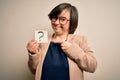 Young down syndrome business woman holding question mark paper as doubt symbol very happy pointing with hand and finger Royalty Free Stock Photo